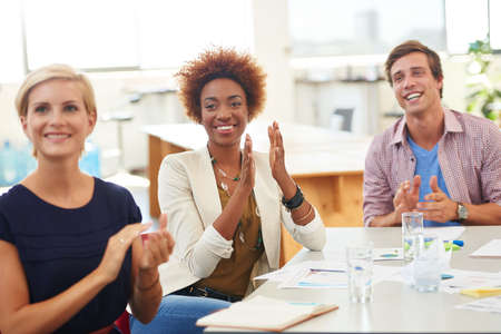 Motivated after an awesome presentation. Shot of a team of young professionals in a business...