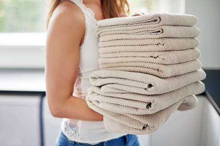 Its laundry day. Cropped shot of young woman doing laundry at home.の写真素材