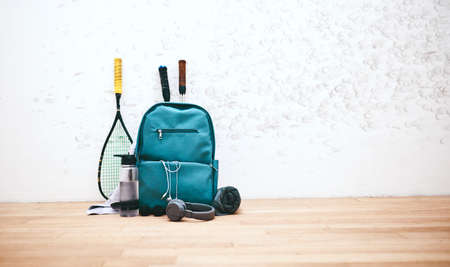 Gear fit for a pro. Shot of a sports bag and other items in an empty squash court.の写真素材
