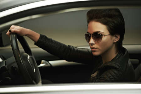 Stylish in her shades and luxury car. A gorgeously stylish woman in shades in her luxury car.