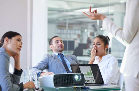 This meeting is taking forever. Cropped shot of a group of business colleagues meeting in the...