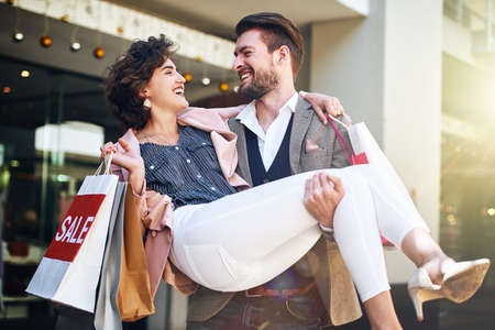 He treats me like a Queen. Shot of a playful couple out on a shopping spree.の写真素材