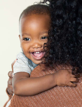 Im Mommys little angel. Shot of an unrecognizable mother holding her adorable son at home during the day.の写真素材