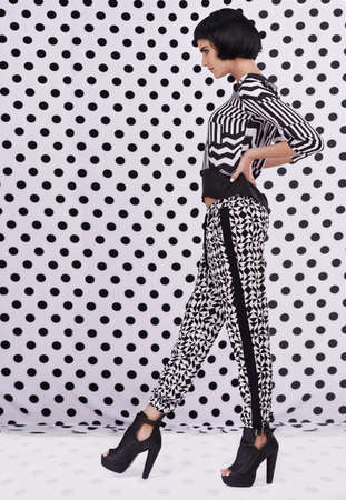 Polka dot style. Studio shot of a retro-stylish young woman against a black and white polka dot...