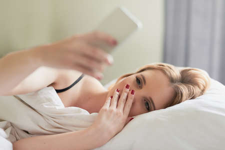 Checking out her social media feeds. Shot of an attractive young woman texting on her cellphone...