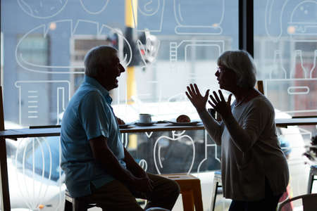 Catching up over coffee. Cropped shot of an affectionate senior couple in their local coffee shop.の写真素材