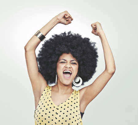 Freak out. Studio shot of a young woman in a retro outfit shouting with excitement while dancing.