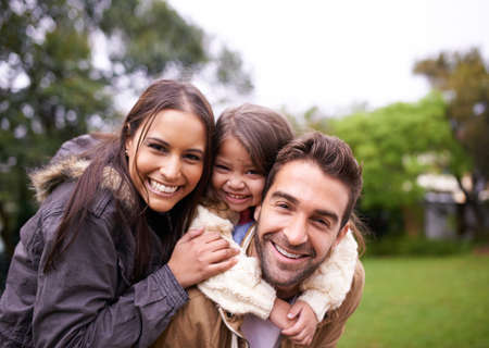 Family bonding time. Shot of a young family of three enjoying a day in the park.の写真素材