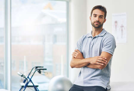 Devoted to my patients health. Cropped portrait of a male physiotherapist sitting with his arms...