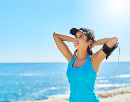 I dont run for vanity, I run for sanity. Cropped shot of a young woman listening to music while out...