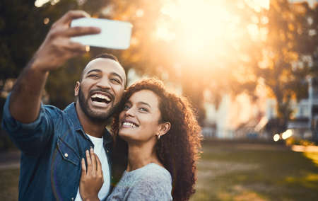 The world will know about our true love. Shot of a young couple taking selfies together outdoors.
