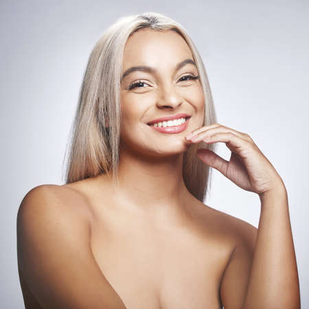 Beauty lies within simplicity. Shot of an attractive young woman standing alone and posing against a grey background in the studio.の写真素材