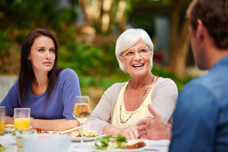 Good food and great conversation. Shot of a mother having lunch outside with her adult son and...