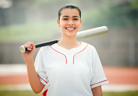 Batter up. Cropped portrait of an attractive young female baseball player holding a baseball bat while standing outside.の写真素材