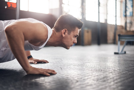 You were built to be the best. Shot of a young man doing pushups in a gym.