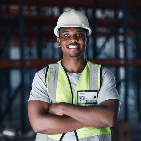 Your shipment is safe in our warehouse. Shot of a handsome young contractor standing alone in the...