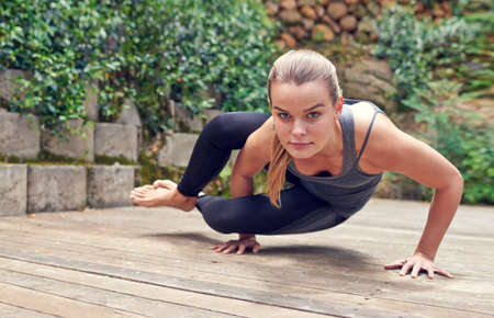 Strong mind, strong body. Shot of a young woman practicing yoga outdoors.