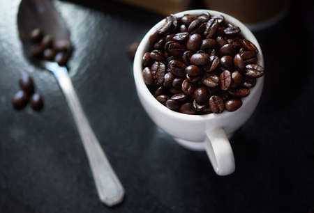 Awaken your senses. Studio shot of coffee beans in a cup and on a spoon.