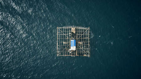 A kelong is the closest thing to working from home. High angle shot of a built fishing structure floating in the middle of the ocean called a kelong.の写真素材