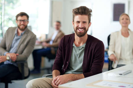 Modern leadership looks full of promise. Smiling creative professional with colleagues in the...