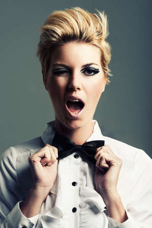 Twiggy would be proud. Studio shot of an attractive young woman posing against a gray background.