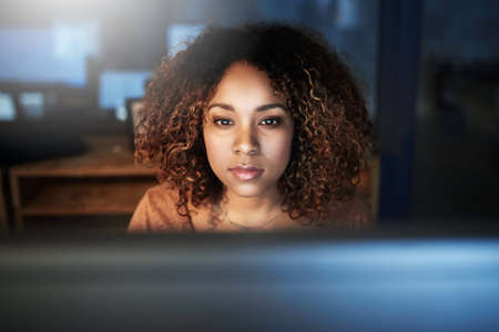 Getting it right, no matter the hour. Shot of a young woman working late in an empty office.
