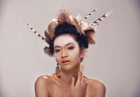 Natural is now. A portrait of a young woman in a native american-inspired headdress.の写真素材