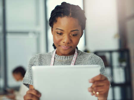 Showcasing her new designs with an online marketing campaign. Shot of a fashion designer looking at...
