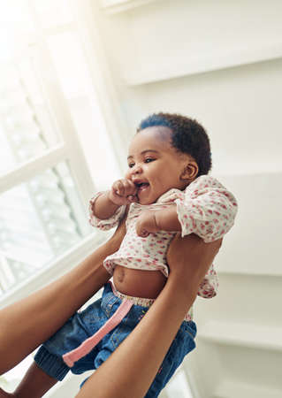 Shes quite playful. Shot of a mother holding her smiling baby girl.