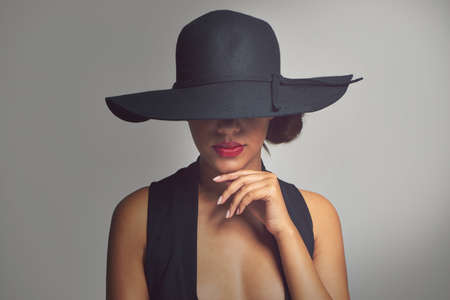 Beauty with a hint of mystery. Studio shot of a stylishly dressed young woman.の写真素材