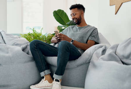 This is such a funny text. Cropped shot of a handsome young businessman sitting alone and using his...