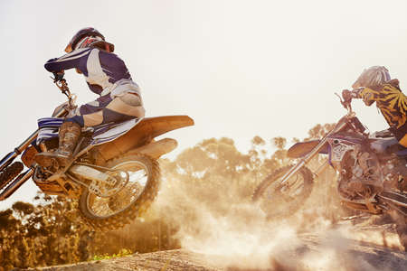 Time to rip up this track. A shot of two dirtbike racers going head-to-head on the track.の写真素材