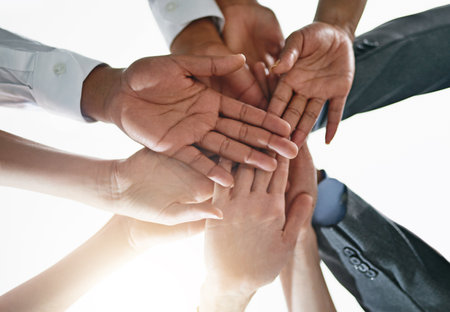 Strengthened as a team. Closeup shot of a group of businesspeople joining their hands together in unity.の写真素材