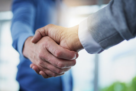 Forming a new merger. Closeup shot of a two unrecognizable businessmen shaking hands in an office.の写真素材