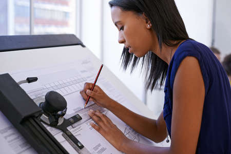 This is what she does best. Cropped shot of an attractive female architect working at a drawing...