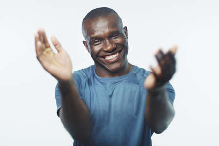 You deserve a round of applause, well done. Studio shot of a handsome young man clapping his hands against a grey background.の写真素材