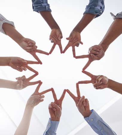 Dont forget that youre a star. Shot of a group of unrecognizable businesspeople making a star shape...