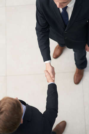 I look forward to collaborating together. Shot of two businesspeople shaking hands in an office.の写真素材