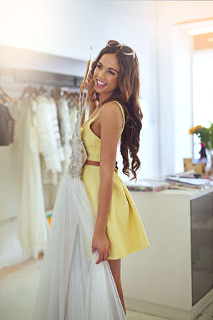ITs beautiful and right on budget. Cropped shot of an attractive young woman searching for a wedding dress.の写真素材