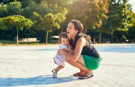 You growing heavier each day. Shot of a young mother and her little girl outdoors.の写真素材