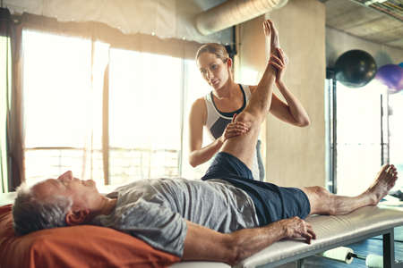 Helping people maximise their functional ability. Shot of a senior man being treated by a...