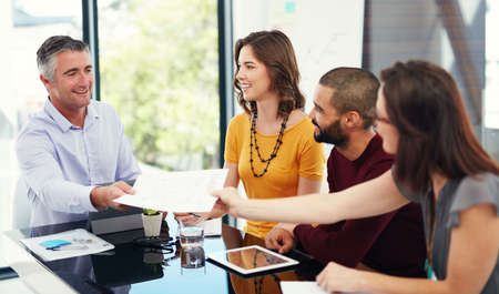 Heres the paperwork you asked for. Cropped shot of a group of businesspeople in a meeting.