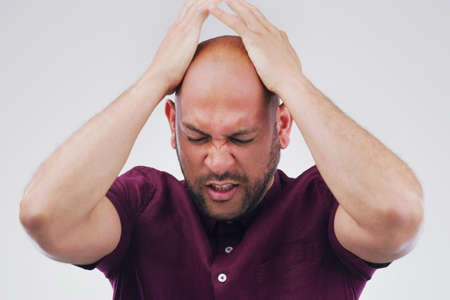 Its like a weight on his shoulders. Studio shot of a handsome young man looking stressed out against...