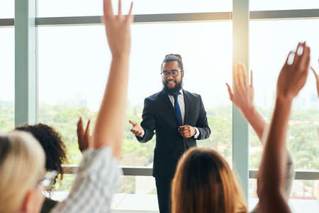 Okay, question time.... Cropped shot of a handsome young businessman fielding questions from his colleagues during a seminar.の写真素材