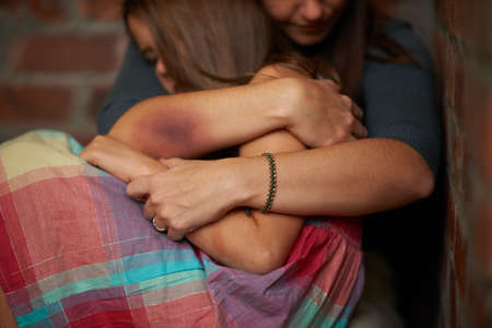 Itll be okay.... Abused woman embracing her frightened daughter.