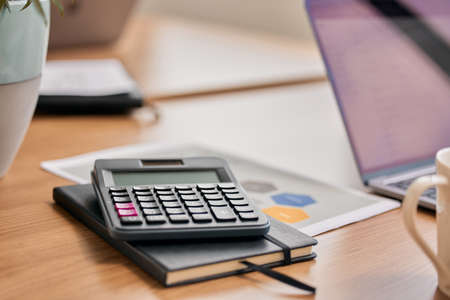 Keeping track of any and all calculations. Still life shot of a calculator and notebook on a desk in...
