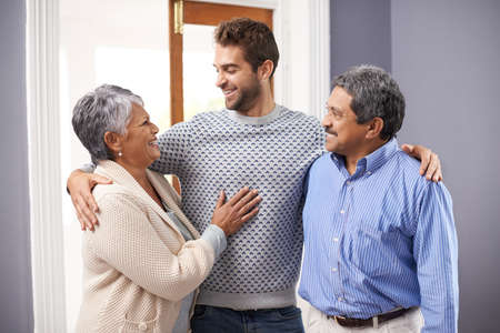 Its time for me to look after you. Shot of a senior couple embracing standing with their adult son.の写真素材