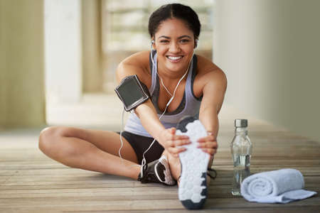 Getting active is a valuable way to improve your happiness. Portrait of a sporty young woman warming...