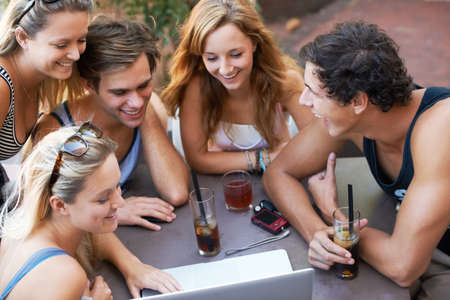 Look at this. Group of teens enjoying beverages while at an outdoor restaurant with all their modern...