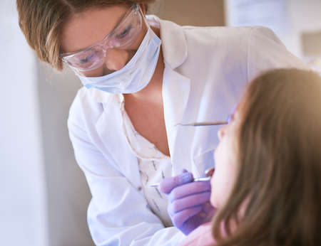 My goal is to provide exceptional care for your child. Cropped shot of a dentist examining a little girls teeth.の写真素材